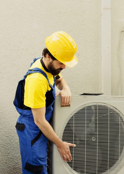 Certified technician getting new outdoor air conditioner ready after replacing old busted unit. Trained engineer contracted to install new condenser and make sure it operates at maximum power