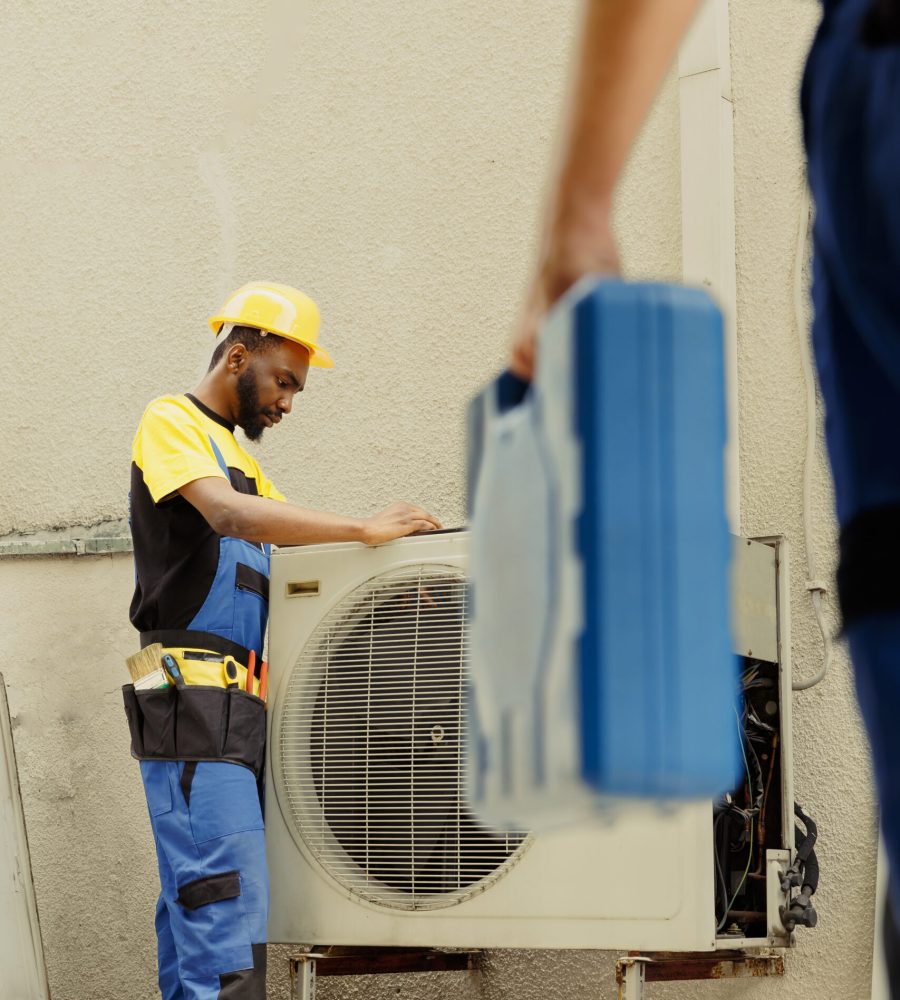 Master serviceman arriving on location to help apprentice worker fix unfunctional compressor in faulty hvac system. Experts coworkers contracted to prevent internal parts breakdowns